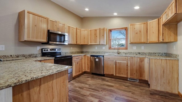 kitchen with sink, stainless steel appliances, dark hardwood / wood-style floors, light stone counters, and light brown cabinetry