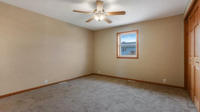 unfurnished room with light colored carpet and ceiling fan