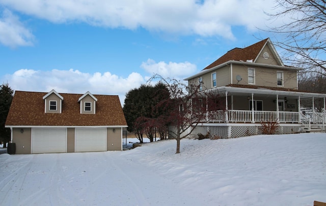 view of snow covered exterior with a garage and covered porch