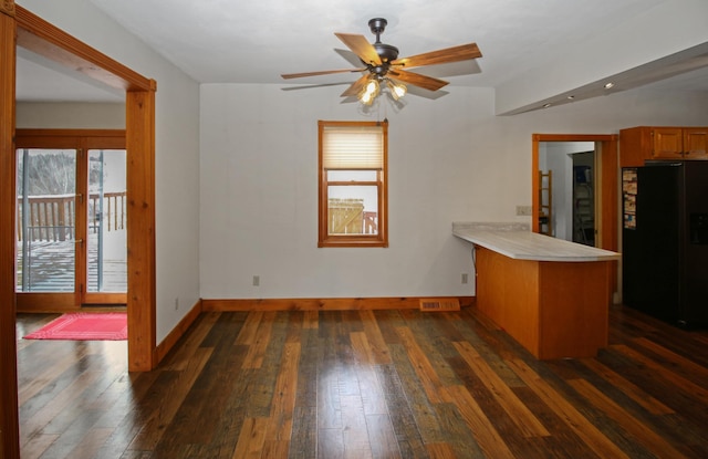 kitchen with dark wood-type flooring, kitchen peninsula, ceiling fan, and black refrigerator with ice dispenser