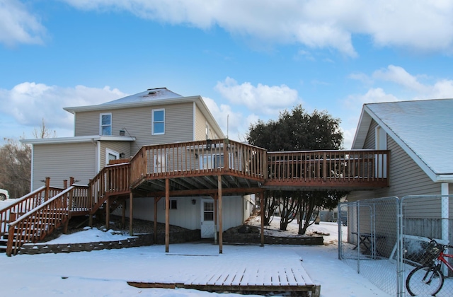 snow covered back of property featuring a deck