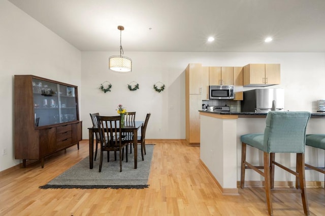 dining area featuring recessed lighting, light wood-type flooring, and baseboards