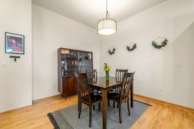 dining area with baseboards and light wood finished floors