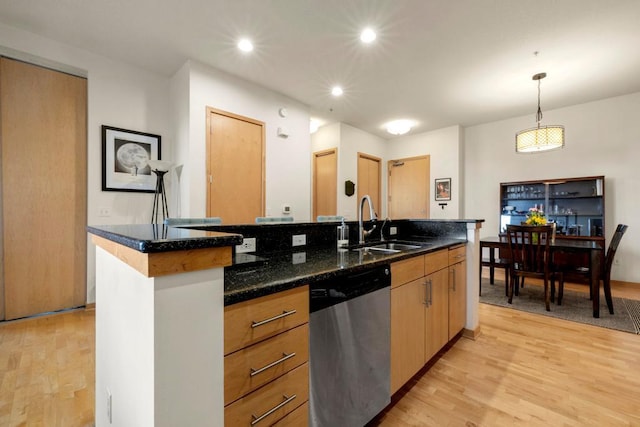 kitchen with a sink, stainless steel dishwasher, recessed lighting, light wood finished floors, and hanging light fixtures