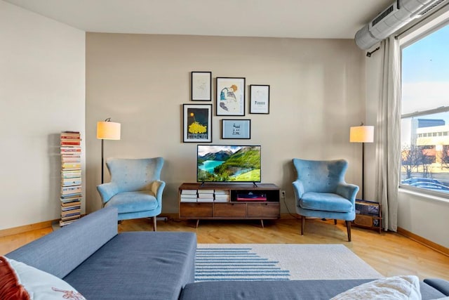 living area featuring baseboards and wood finished floors