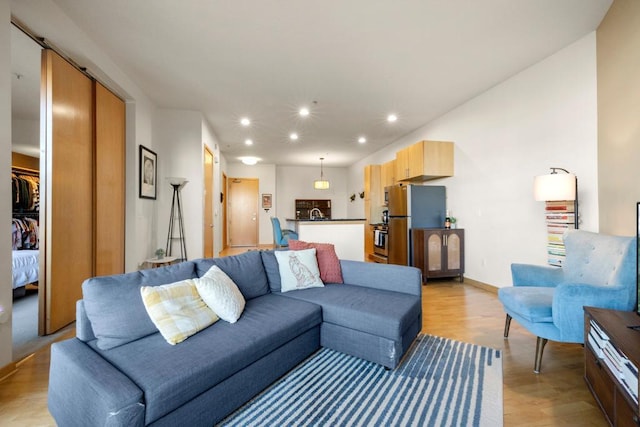 living area with recessed lighting, light wood-type flooring, and baseboards