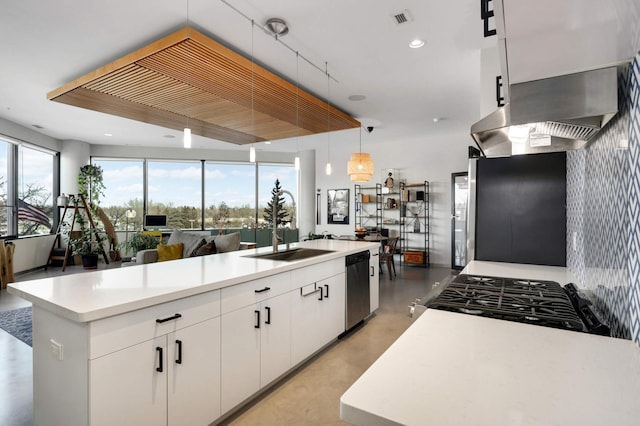 kitchen with hanging light fixtures, a center island with sink, and white cabinetry