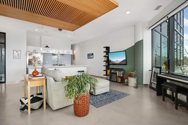 living area featuring baseboards, recessed lighting, visible vents, and finished concrete floors