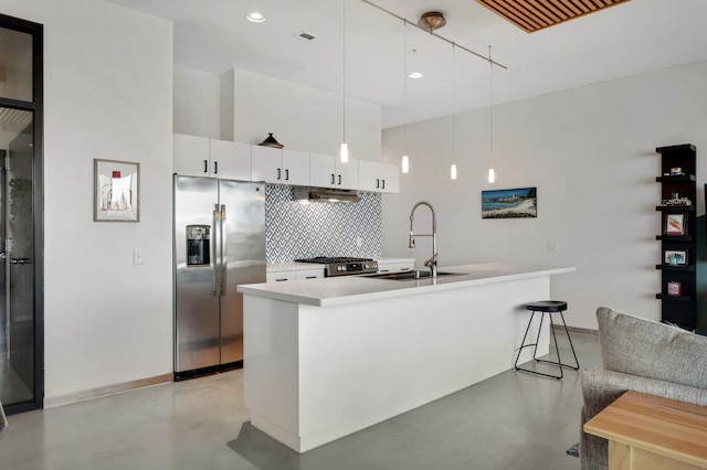 kitchen featuring white cabinets, stainless steel fridge with ice dispenser, light countertops, pendant lighting, and a sink