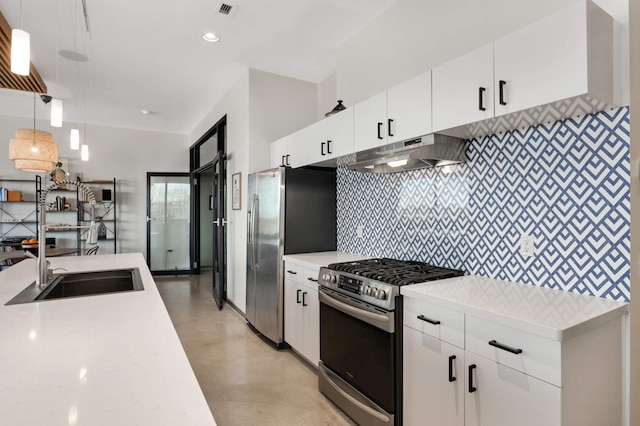 kitchen with under cabinet range hood, stainless steel appliances, white cabinets, light countertops, and decorative light fixtures