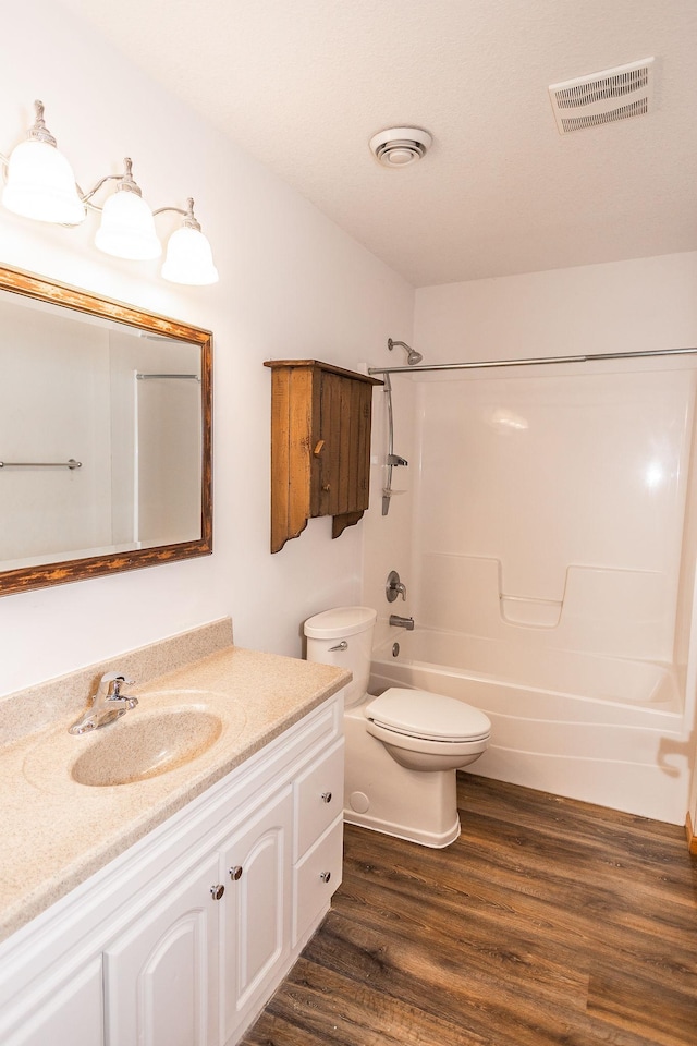 full bathroom with shower / tub combination, vanity, toilet, and hardwood / wood-style floors