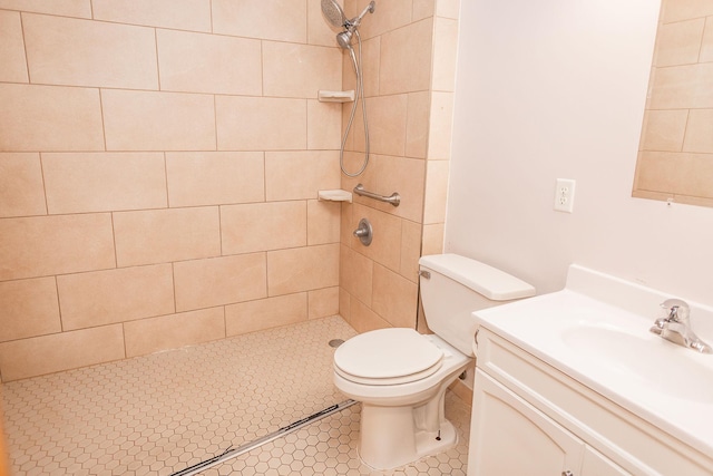 bathroom featuring vanity, toilet, and a tile shower