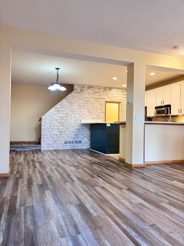 unfurnished living room featuring wood-type flooring and a textured ceiling