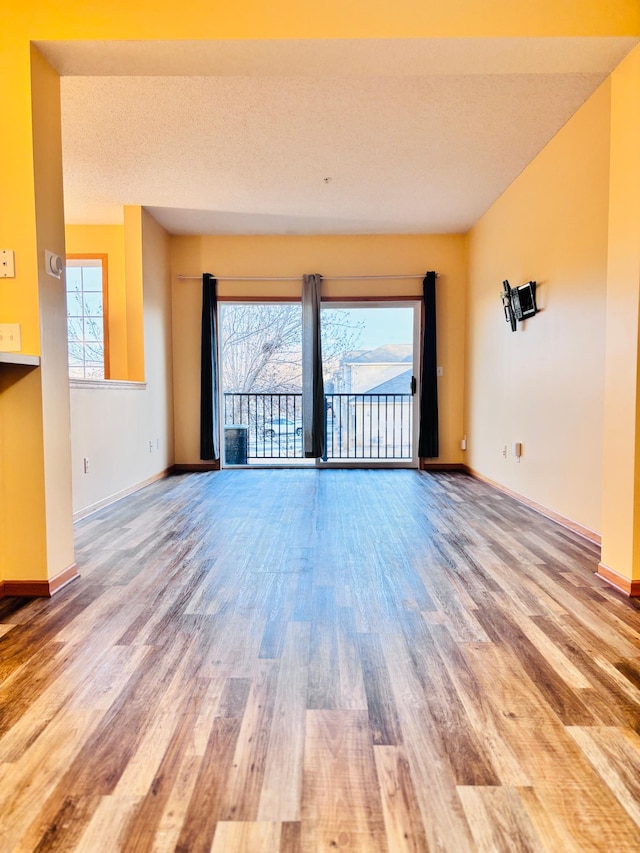 unfurnished living room featuring hardwood / wood-style floors and a textured ceiling