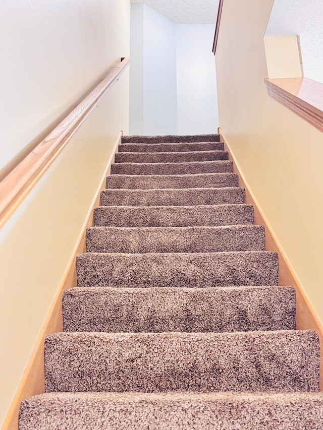 stairs with a textured ceiling