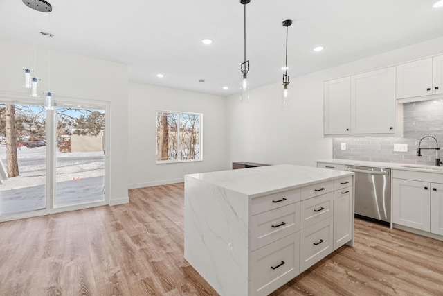 425 8th St Unit 23, New Richmond, WI 54017 - kitchen featuring dishwasher, a sink, decorative backsplash, light wood-style floors, and a center island