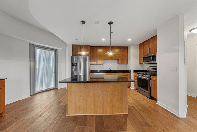 929 Portland Ave Unit 406, Minneapolis, MN 55404 - kitchen with stainless steel appliances, light wood-style floors, dark countertops, a center island, and recessed lighting