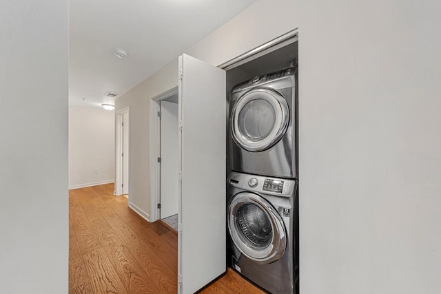 929 Portland Ave Unit 406, Minneapolis, MN 55404 - washroom featuring stacked washing machine and dryer and light wood-style floors
