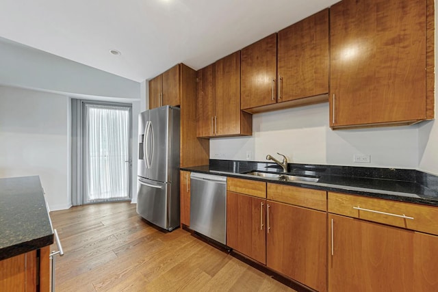 929 Portland Ave Unit 406, Minneapolis, MN 55404 - kitchen with stainless steel appliances, a sink, light wood finished floors, vaulted ceiling, and dark stone counters