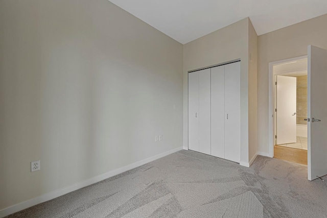 929 Portland Ave Unit 406, Minneapolis, MN 55404 - unfurnished bedroom featuring carpet floors, baseboards, and a closet