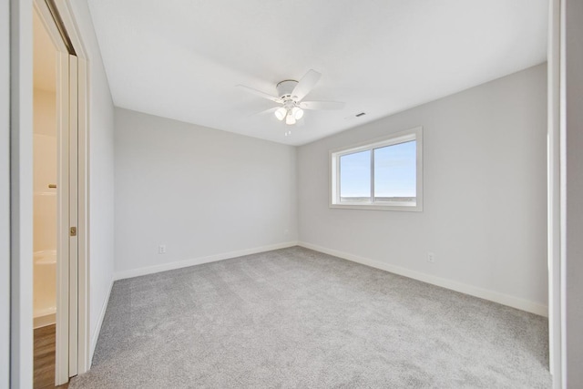 carpeted spare room featuring ceiling fan