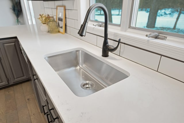 interior details featuring dark hardwood / wood-style floors, sink, and decorative backsplash