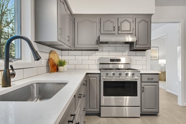 kitchen featuring sink, stainless steel range with gas stovetop, and gray cabinetry