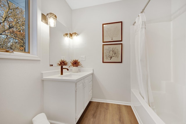 bathroom with hardwood / wood-style flooring, shower / bath combo, and vanity