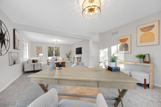 dining room featuring light carpet and a notable chandelier