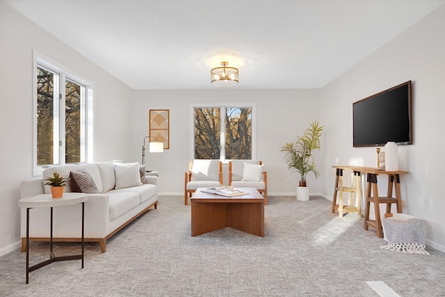 carpeted living room featuring a notable chandelier