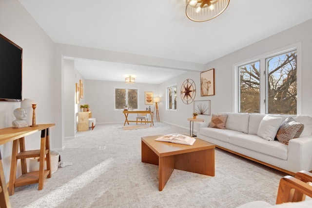 living room featuring light carpet, a wealth of natural light, and a chandelier