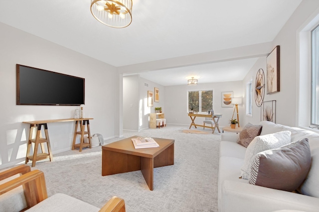 living room featuring light colored carpet and a chandelier