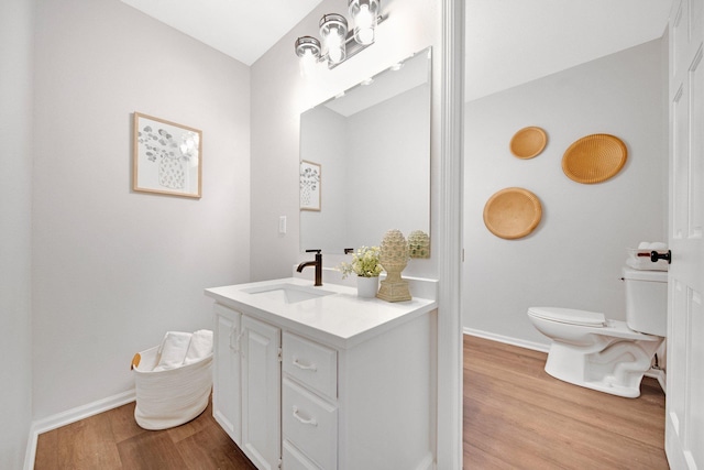 bathroom featuring vanity, wood-type flooring, and toilet