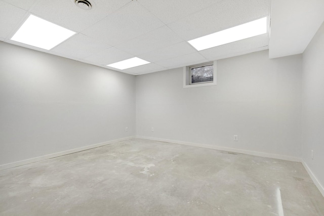 empty room featuring concrete flooring and a paneled ceiling