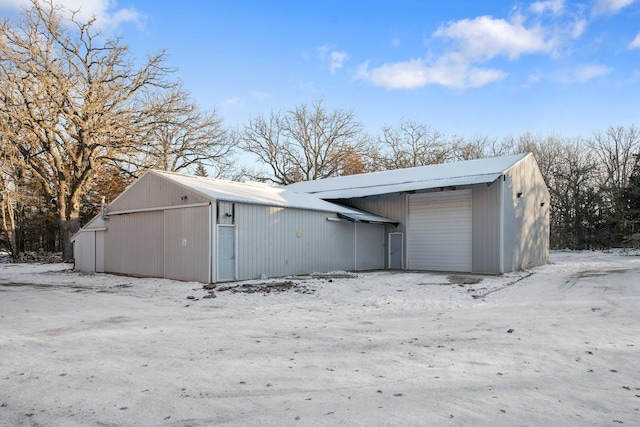 snow covered structure with a garage