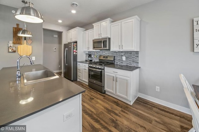 kitchen with decorative light fixtures, sink, white cabinets, backsplash, and stainless steel appliances