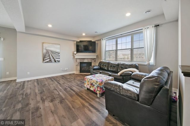 living room featuring wood-type flooring and a tile fireplace