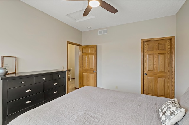 bedroom featuring ceiling fan, visible vents, and attic access