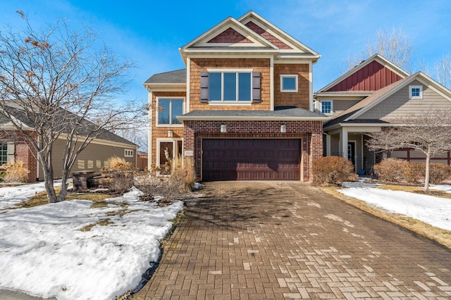 view of front facade with a garage, brick siding, and decorative driveway