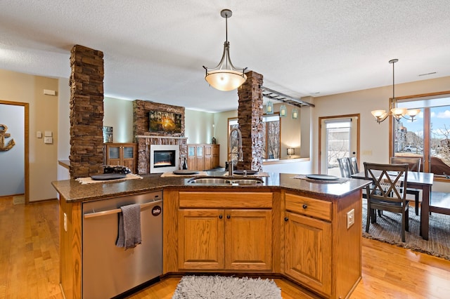 kitchen featuring a sink, open floor plan, brown cabinets, dishwasher, and ornate columns