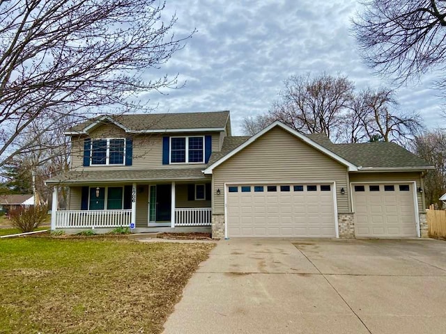 view of front of house featuring a garage, a porch, and a front yard