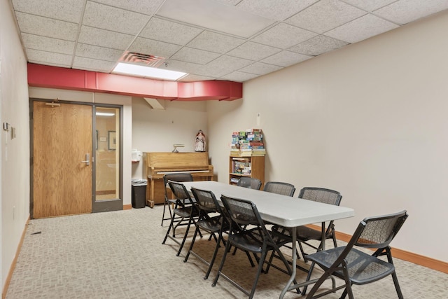 dining room featuring a paneled ceiling and light colored carpet