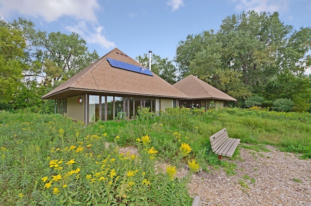 rear view of house featuring solar panels