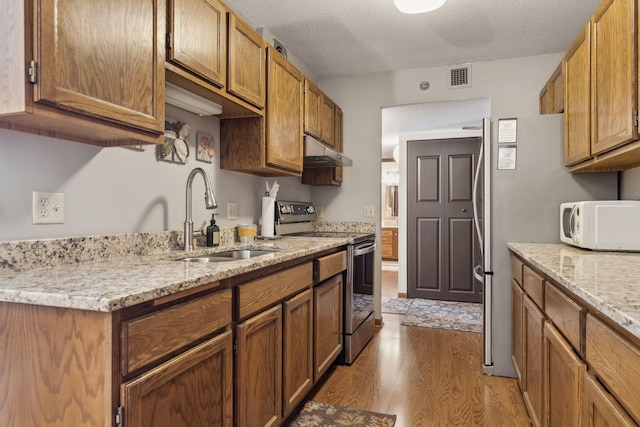 6615 Lake Shore Dr S Unit 403, Richfield, MN 55423 - kitchen with electric range, a sink, under cabinet range hood, white microwave, and wood finished floors