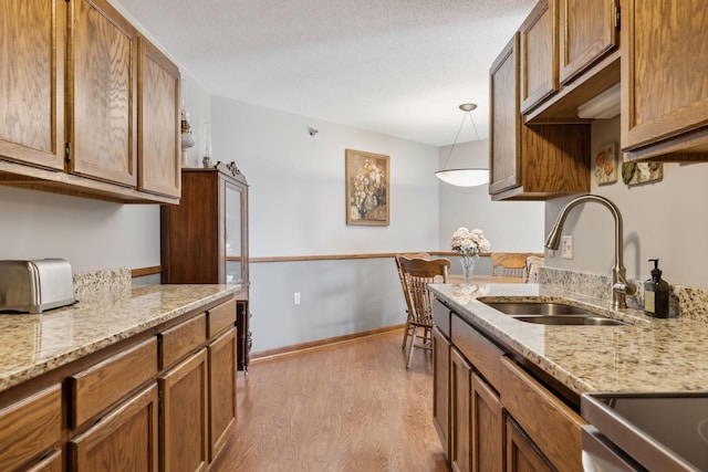 6615 Lake Shore Dr S Unit 403, Richfield, MN 55423 - kitchen featuring a sink, wood finished floors, brown cabinets, and a textured ceiling