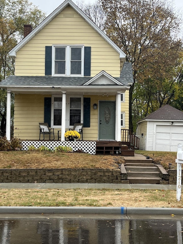 bungalow-style house featuring an outbuilding, a garage, and covered porch