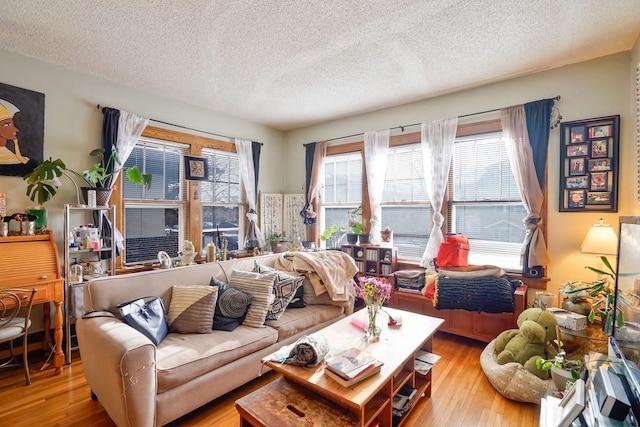 living room with a textured ceiling and light wood-type flooring