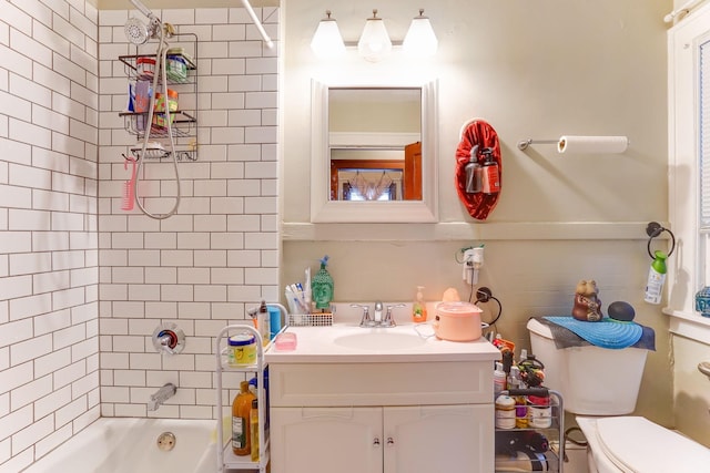 full bathroom featuring tiled shower / bath combo, vanity, and toilet