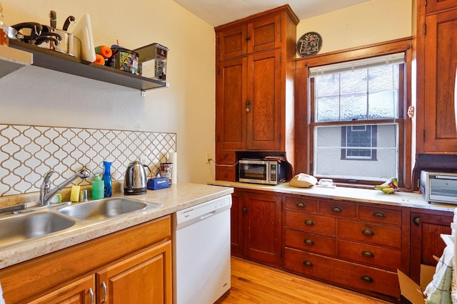 kitchen featuring tasteful backsplash, sink, white dishwasher, and light hardwood / wood-style flooring