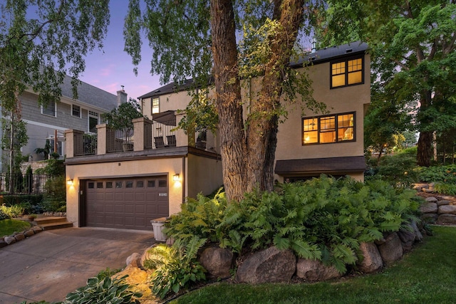 view of front facade with stucco siding, driveway, and a garage